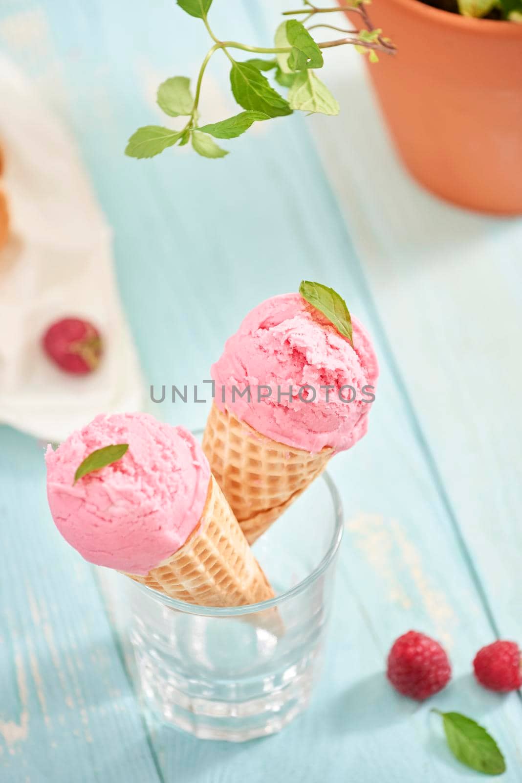 Homemade raspberry ice cream in waffle cones on rustic wooden background, selective focus. Summer time by makidotvn