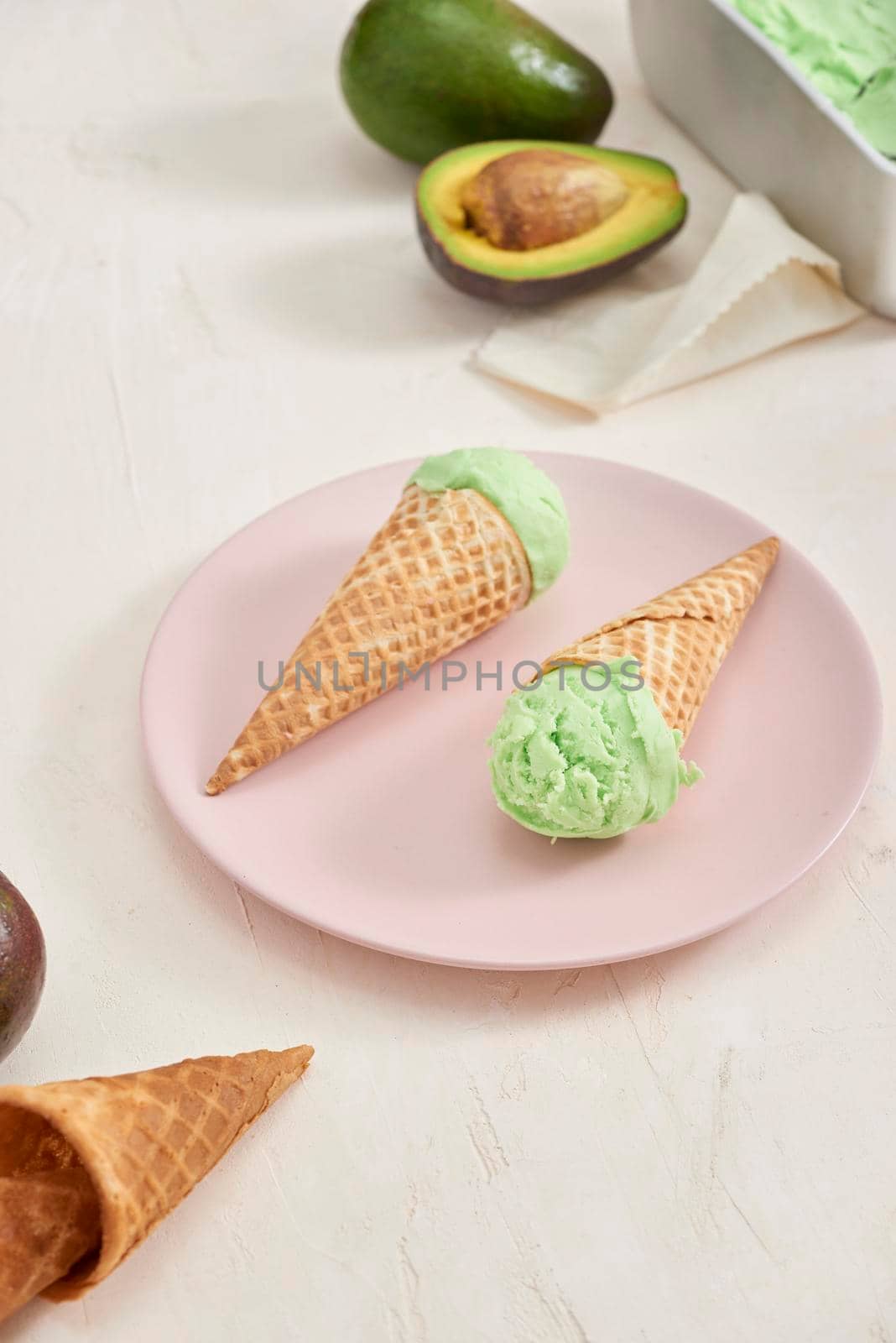 Green avocado ice cream scoops in wafle cones on white background. Copy space by makidotvn