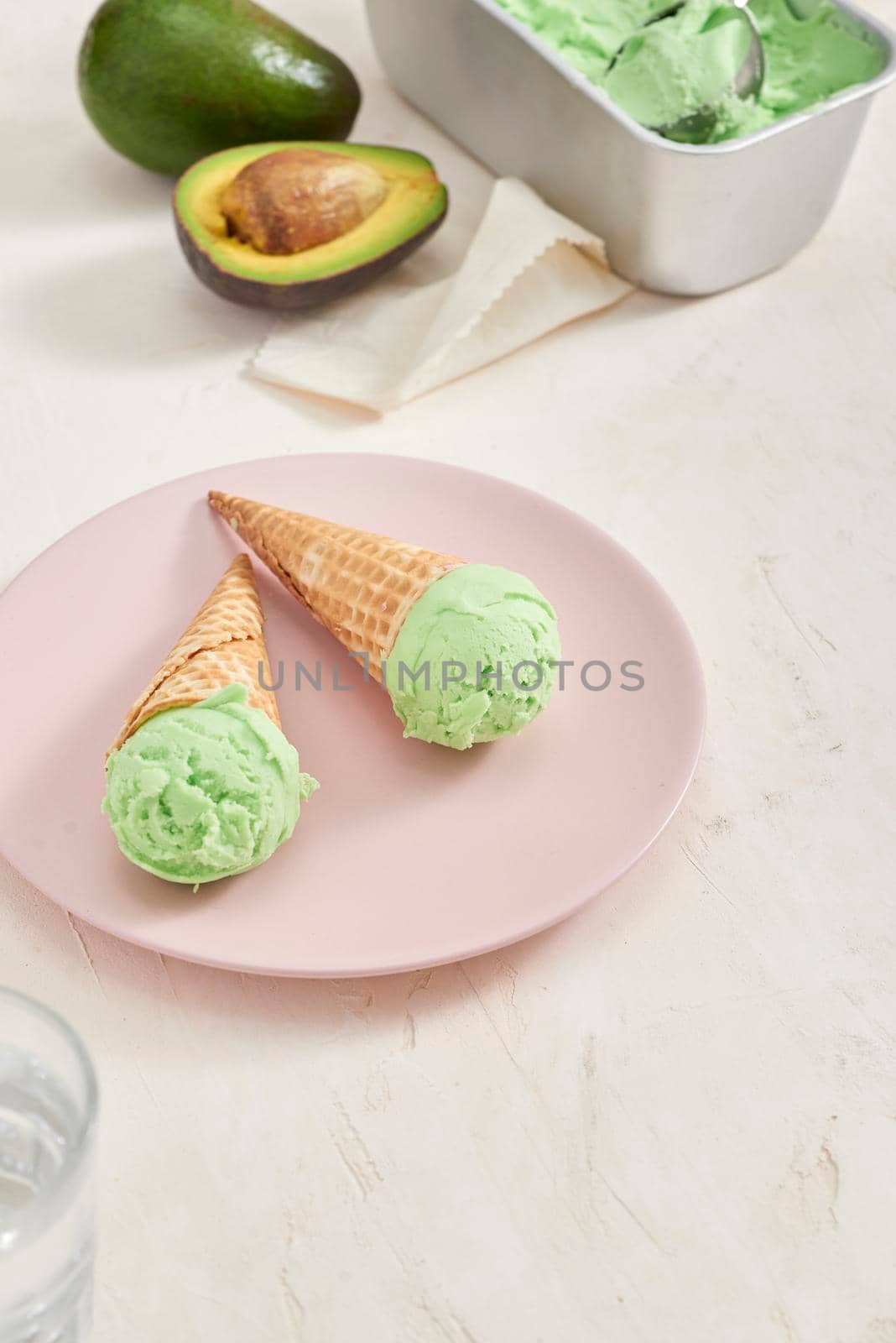 Green avocado ice cream scoops in wafle cones on white background. Copy space by makidotvn