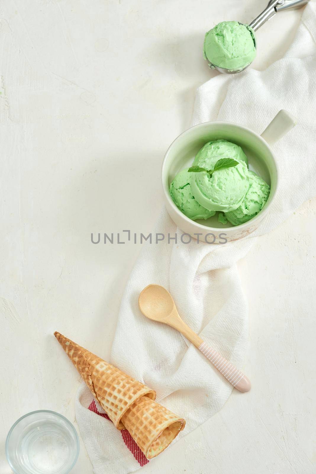 homemade organic avocado ice cream, with ice cream cones. On a grey stone table, copy space