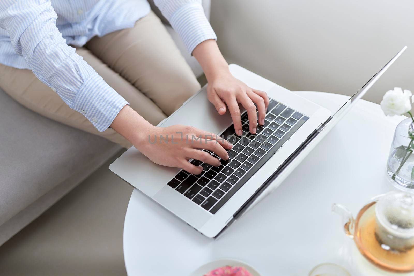 Close up of a woman hands typing in a laptop near window by makidotvn