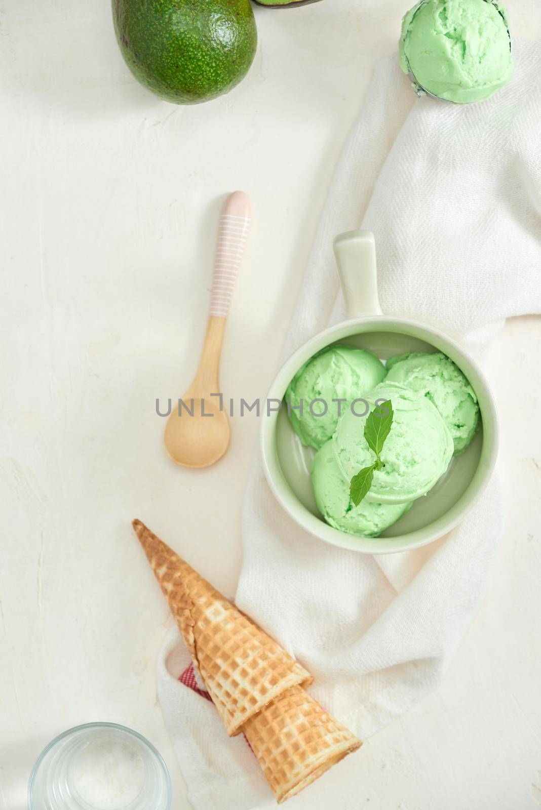 homemade organic avocado ice cream, with ice cream cones. On a grey stone table, copy space by makidotvn