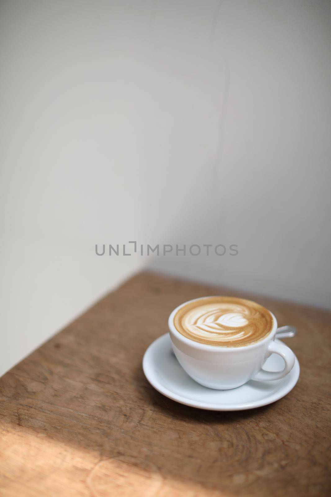 cappuccino or Latte art coffee made from milk on the wood table in coffee shop by piyato