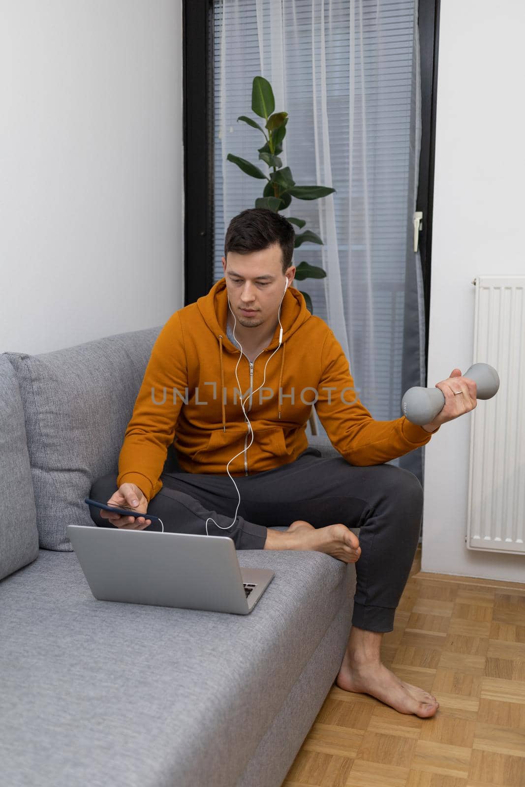 young man exercising at home sitting on couch. High quality photo