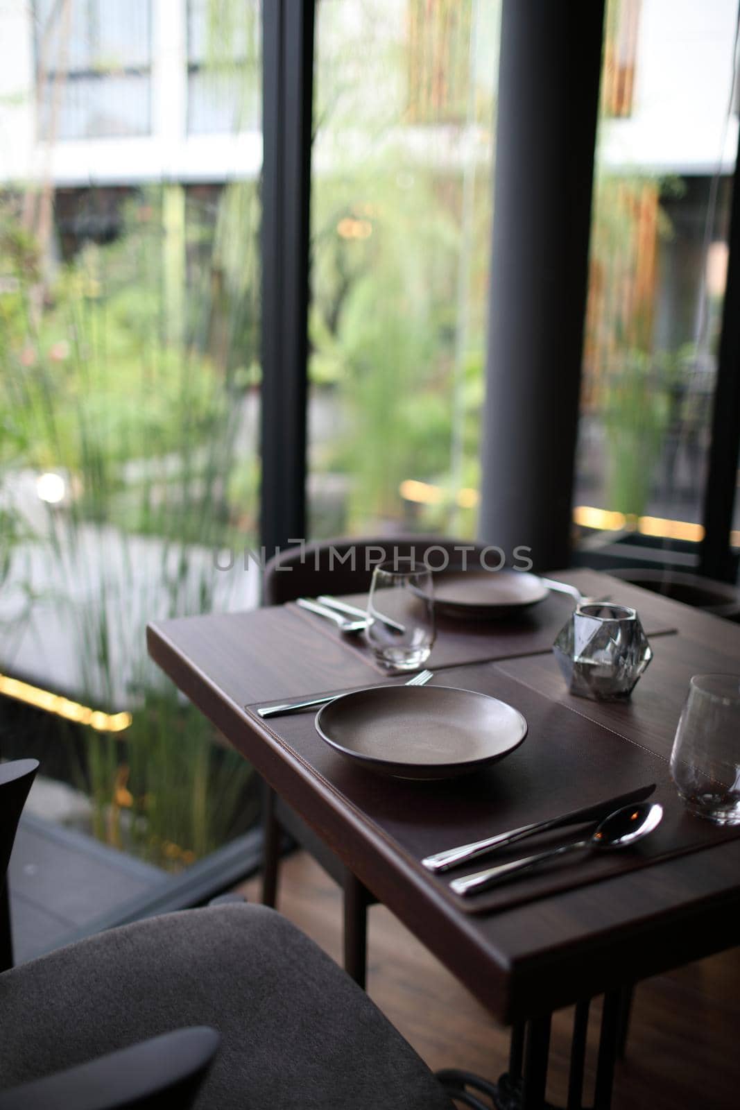 Table set with silverware dish and glass in restaurant by piyato