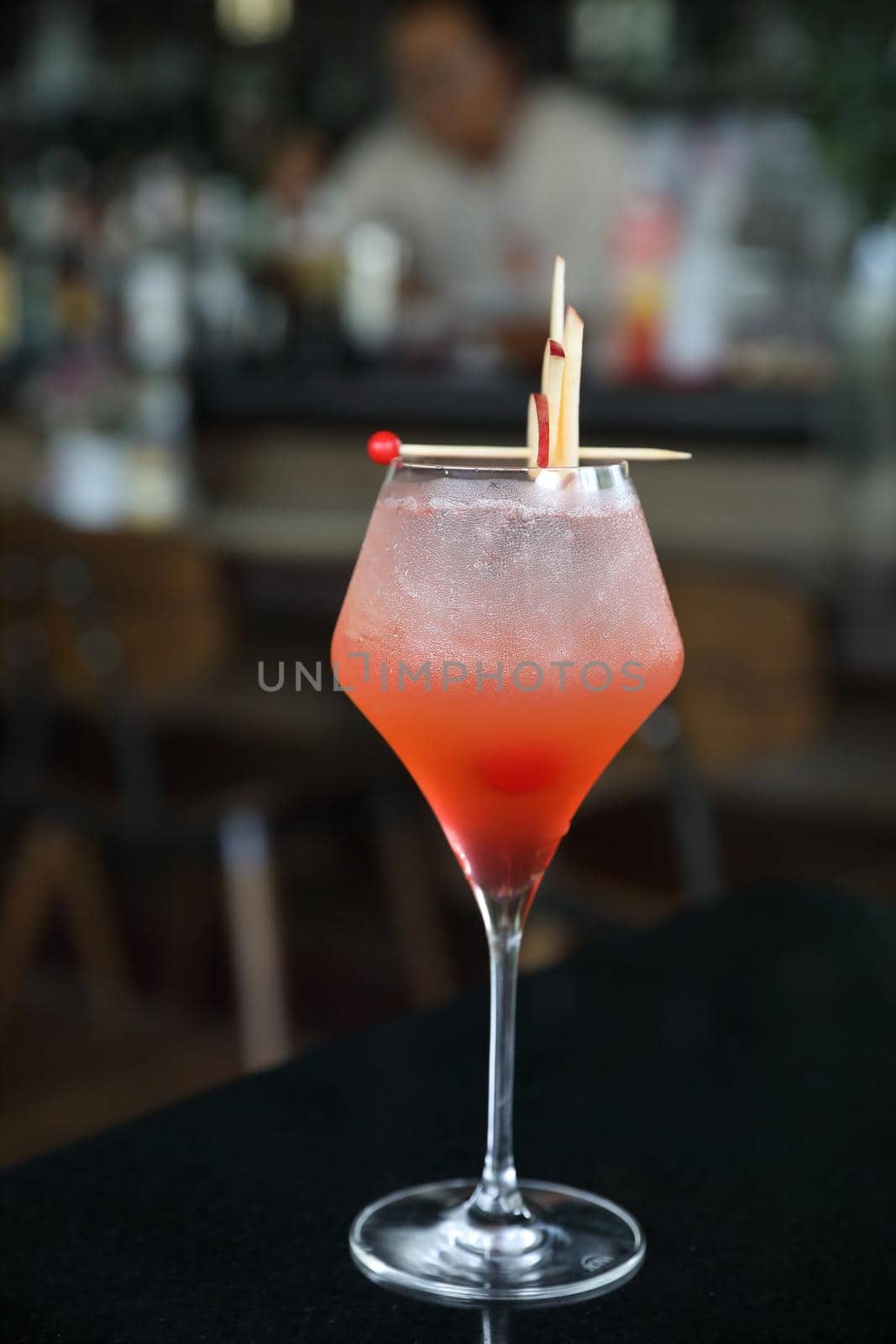 Pink Cocktail glass with ice at a bar counter by piyato