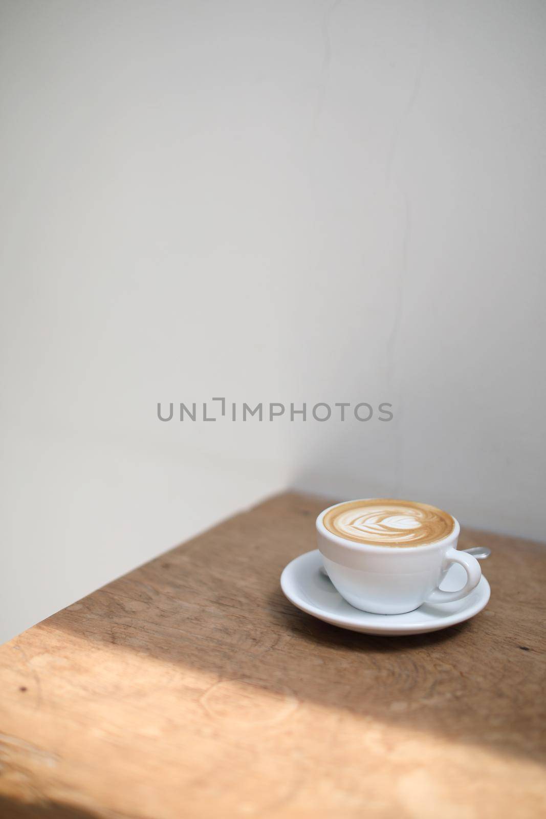 cappuccino or Latte art coffee made from milk on the wood table in coffee shop by piyato