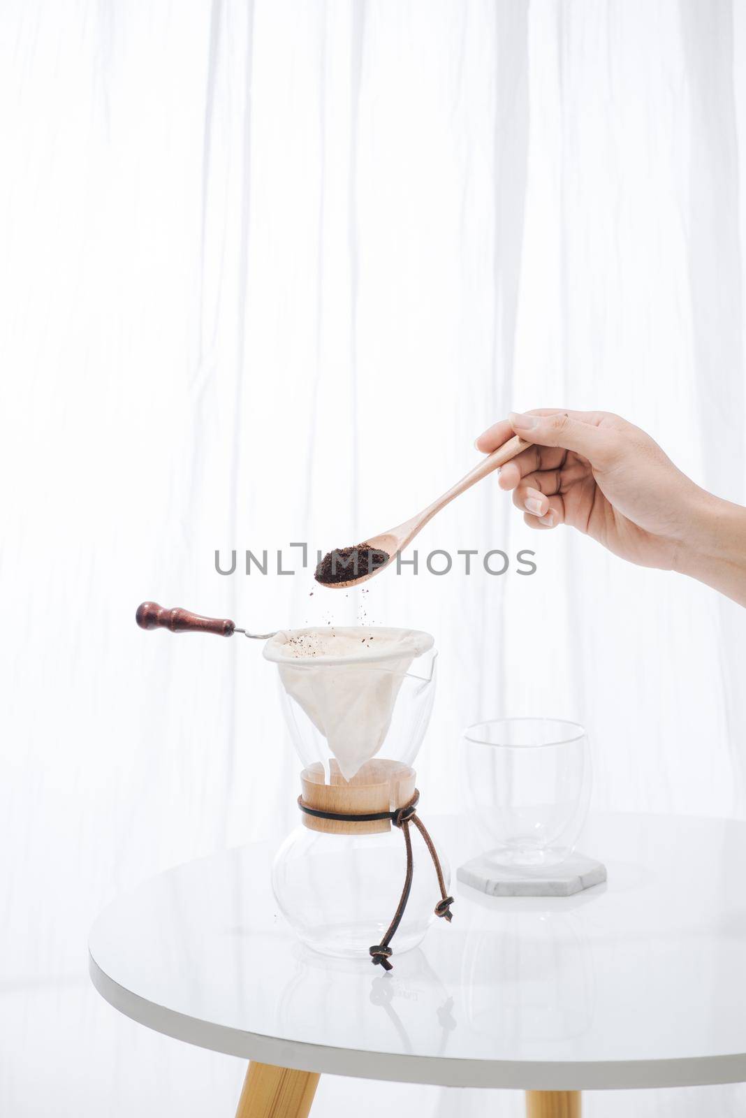 fill grind coffee in filter with wooden spoon