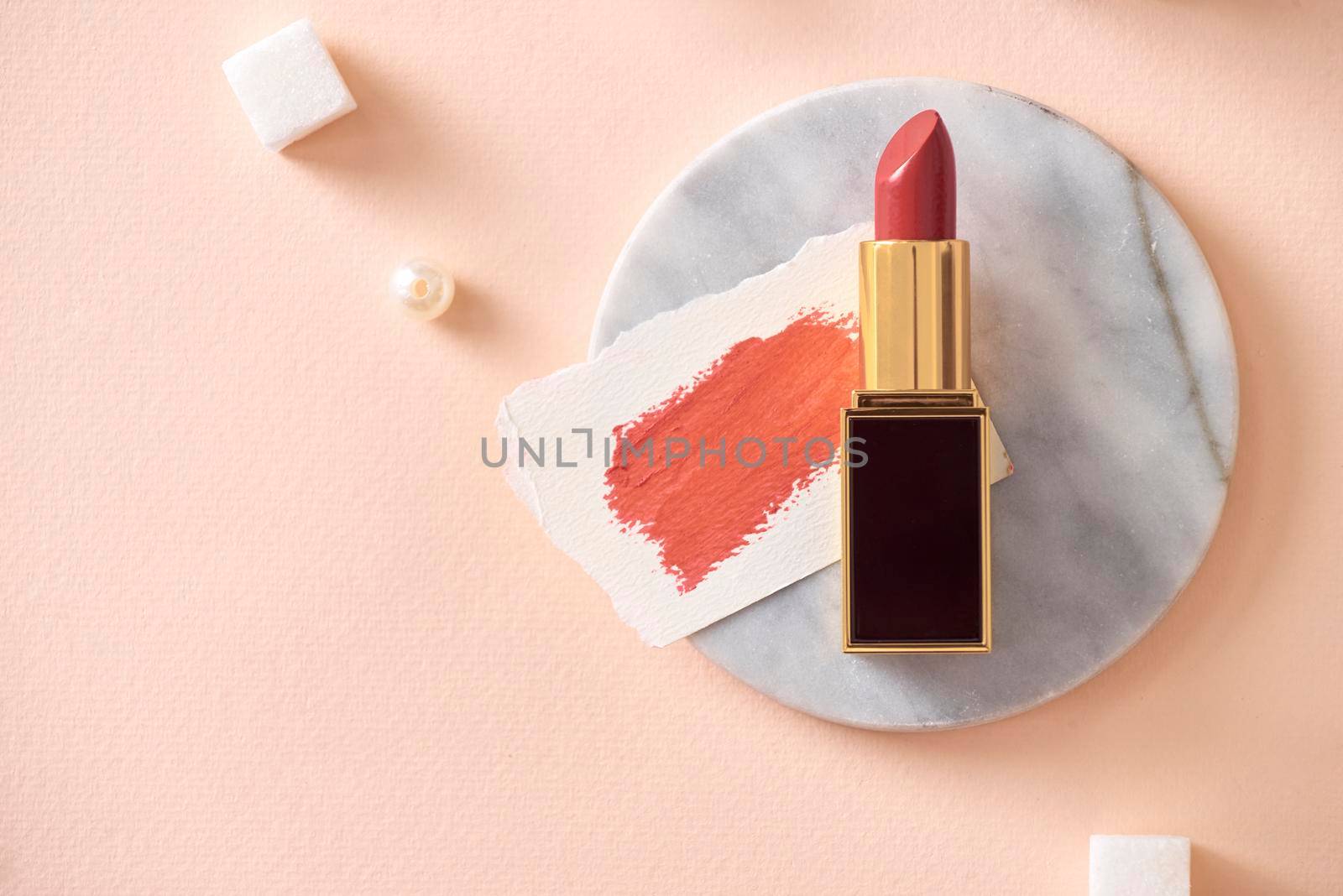 Red lipstick and her smears isolated on orange skin 