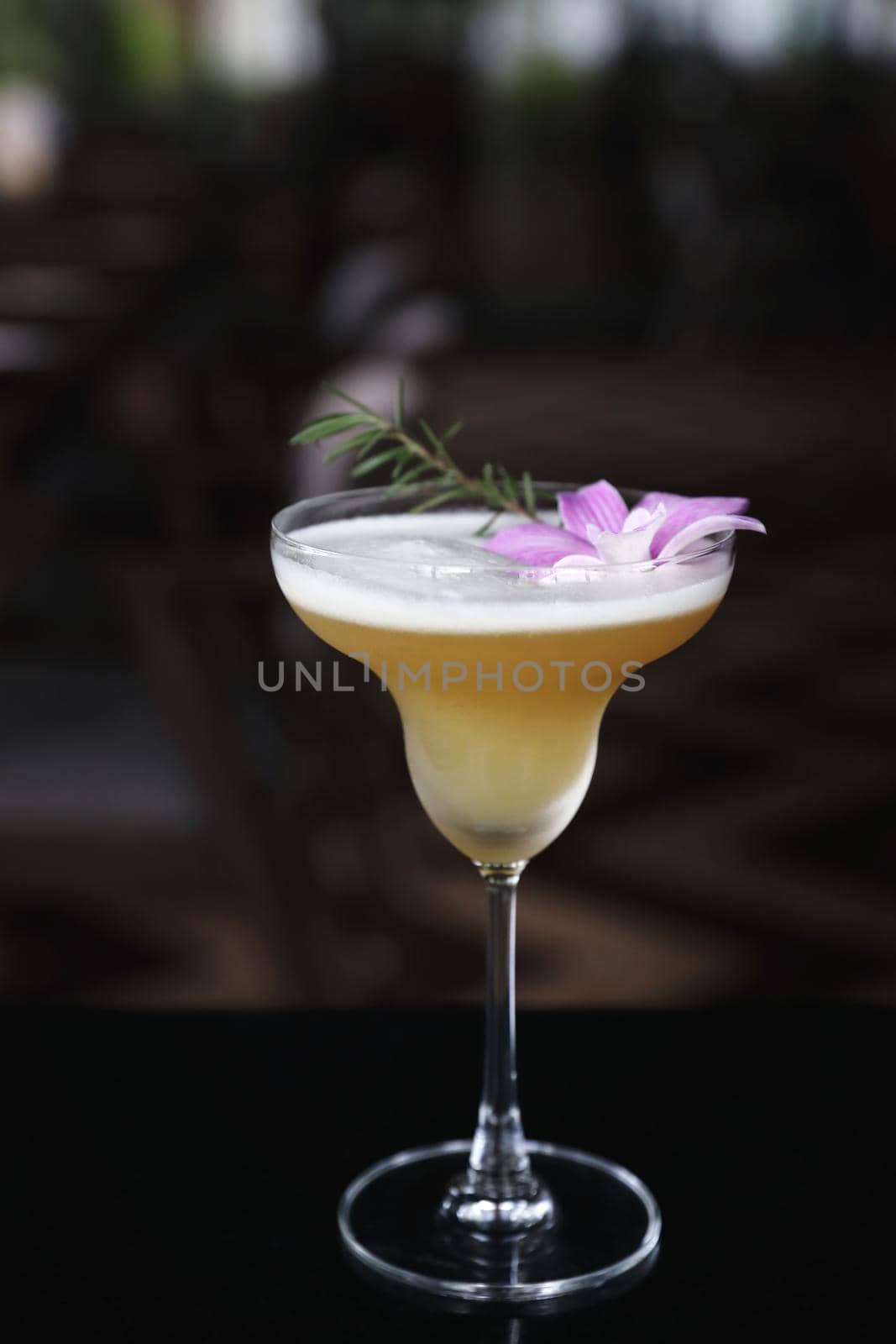 Pink Cocktail glass with ice at a bar counter by piyato