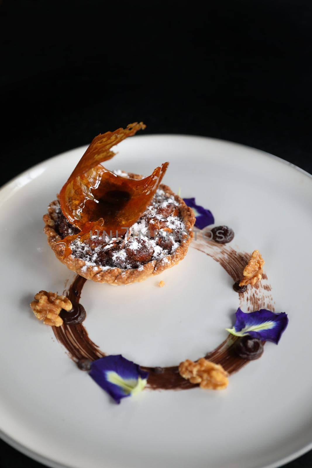 Chocolate dessert cake with berry sauce and almond with decorated