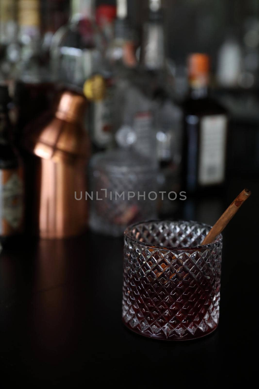 Pink Cocktail glass with ice at a bar counter