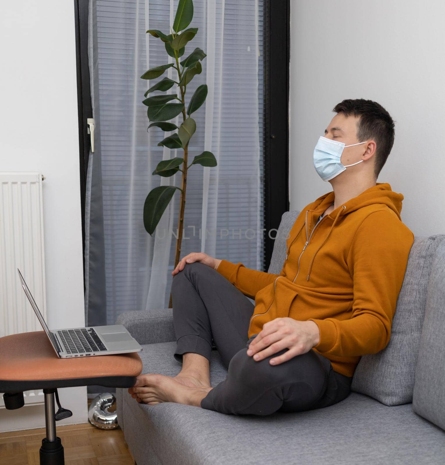 young man exercising at home sitting on couch. High quality photo