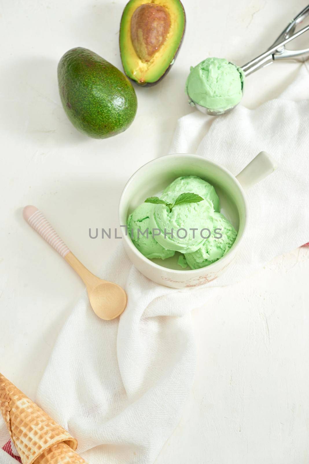 homemade organic avocado ice cream, with ice cream cones. On a grey stone table, copy space by makidotvn