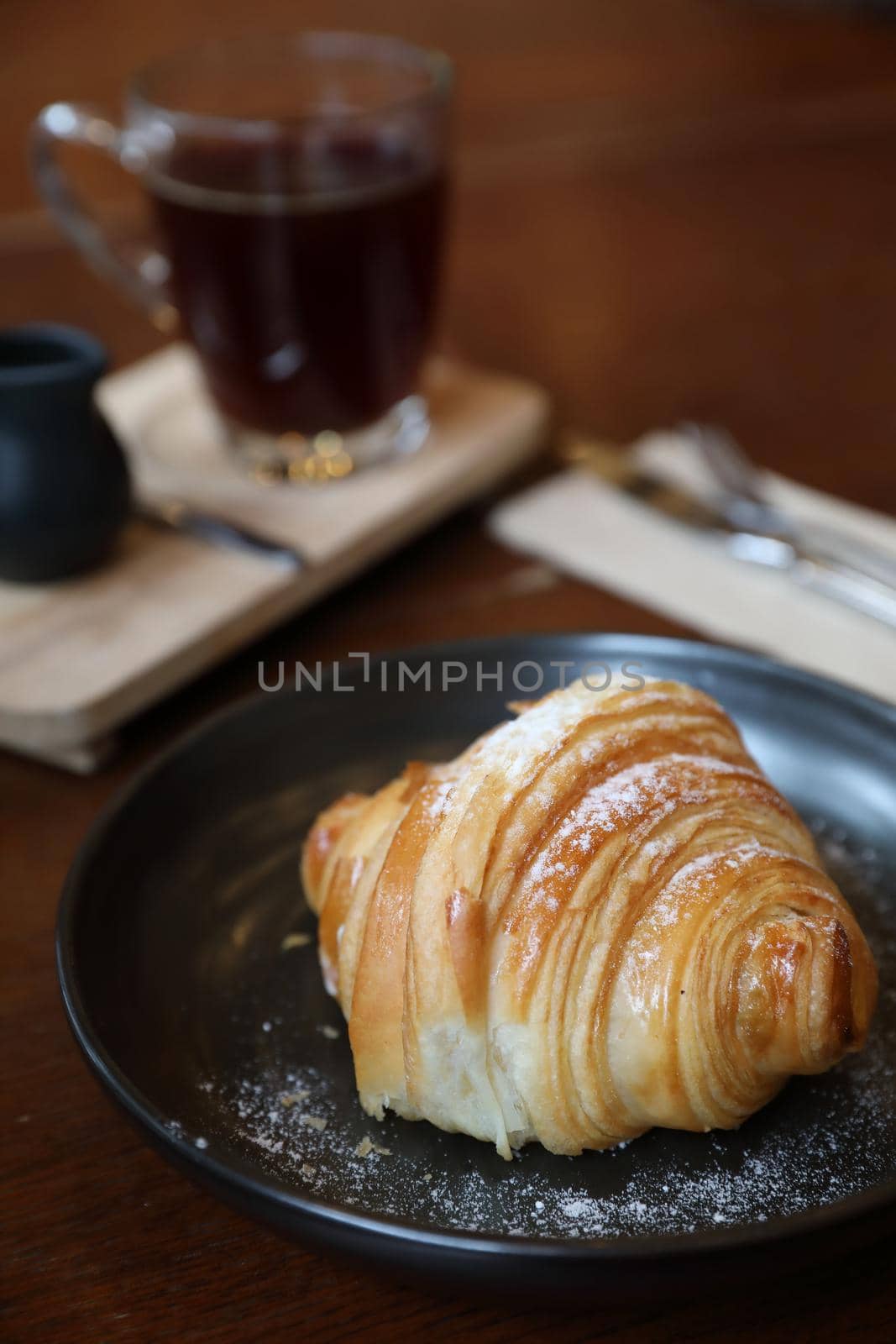 croissant with coffee close up on wood background by piyato