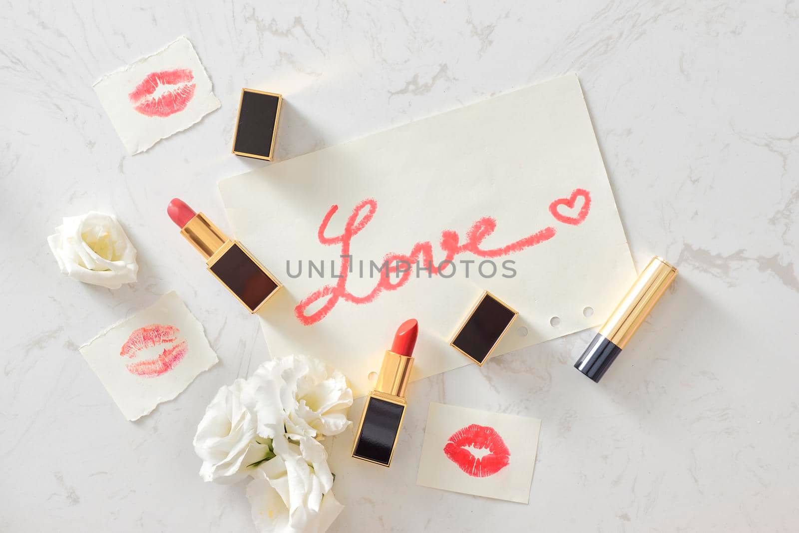 Pink Valentines day flat lay with a lipstick kiss and flowers. Top view