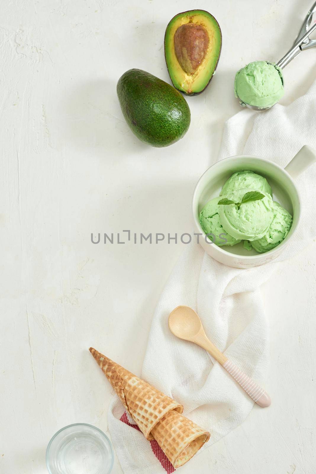 homemade organic avocado ice cream, with ice cream cones. On a grey stone table, copy space by makidotvn