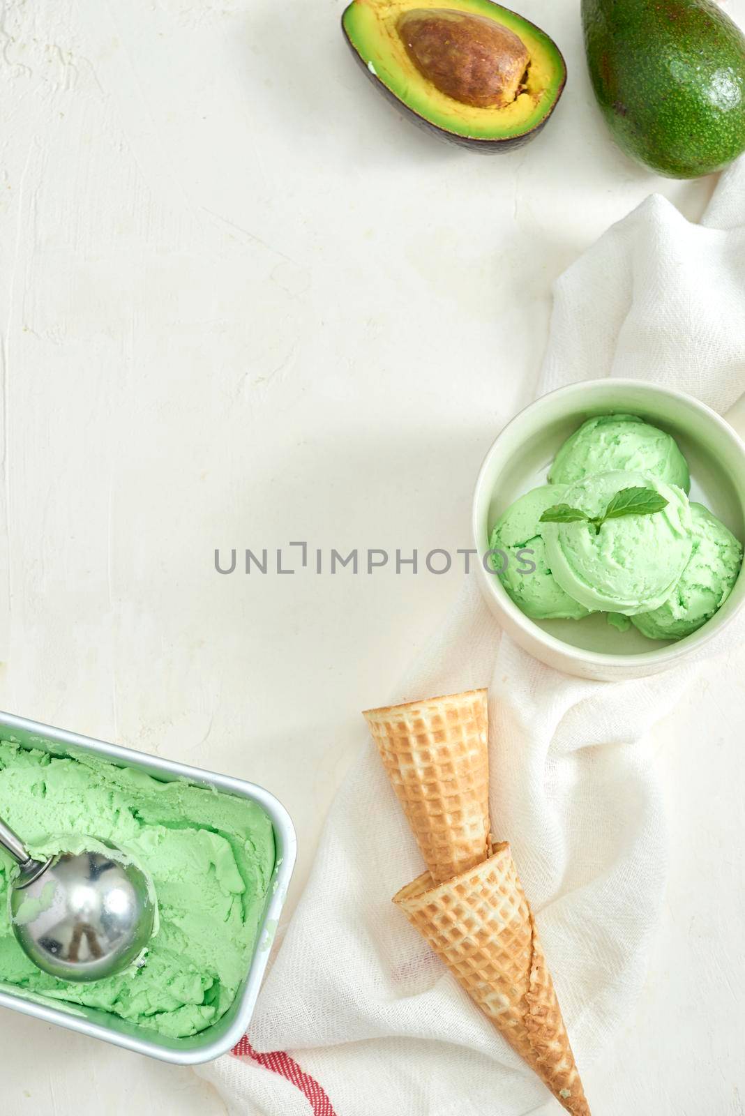 homemade organic avocado ice cream, with ice cream cones. On a grey stone table, copy space by makidotvn