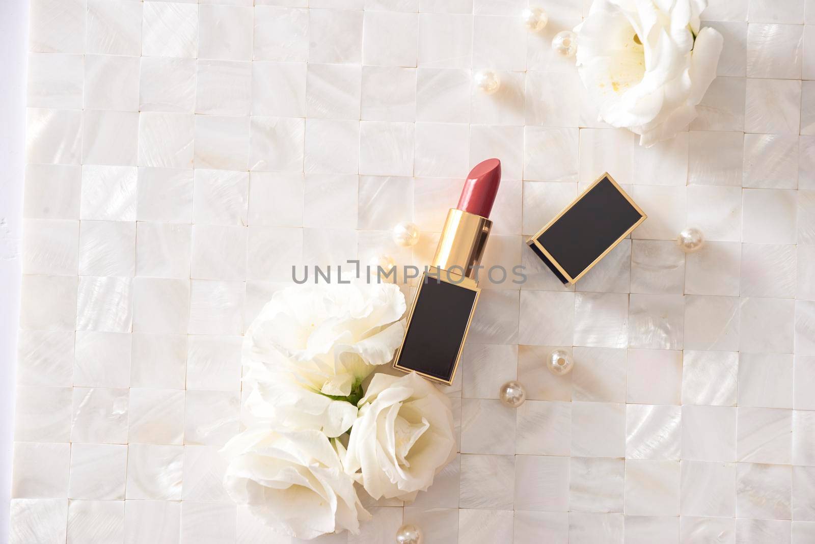 Lipstick with beautiful flowers on white background