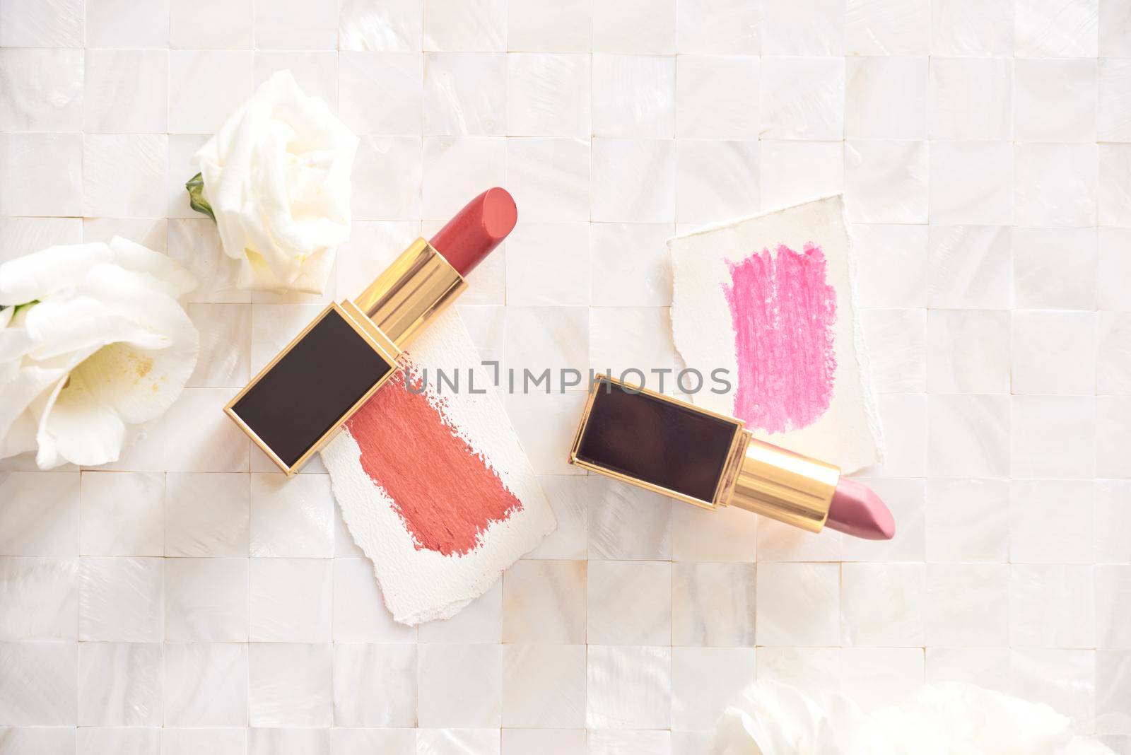 Lipstick with beautiful flowers on white background