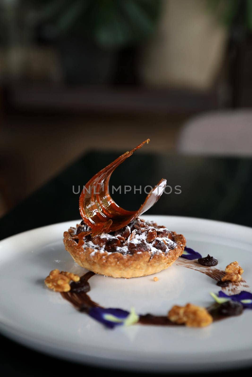 Chocolate dessert cake with berry sauce and almond with decorated by piyato