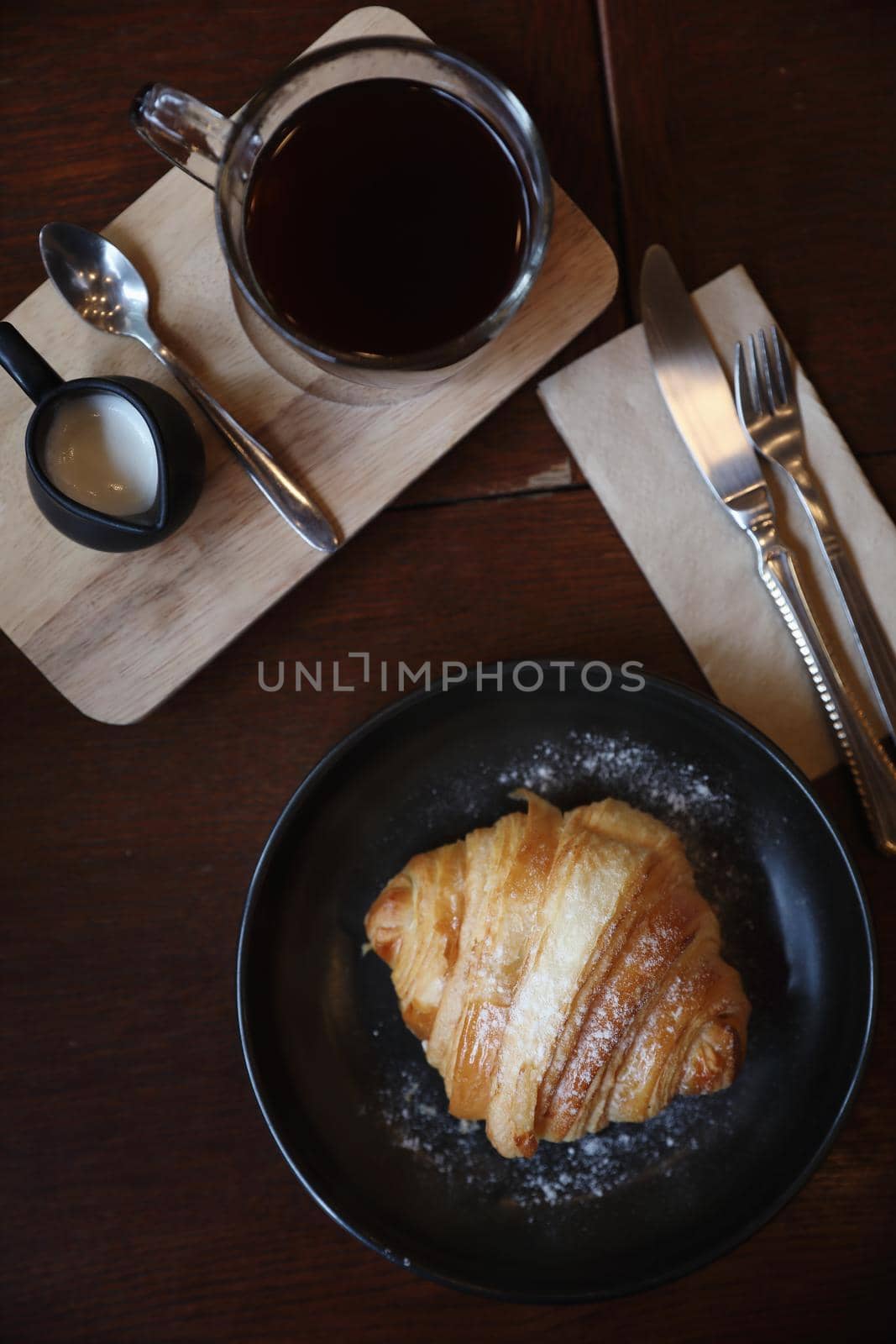 croissant with coffee close up on wood background by piyato