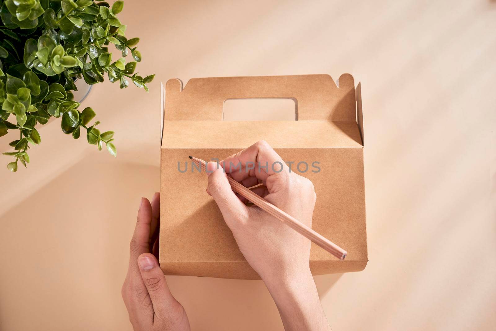  Cropped image of woman writing best wishes on box with present by makidotvn