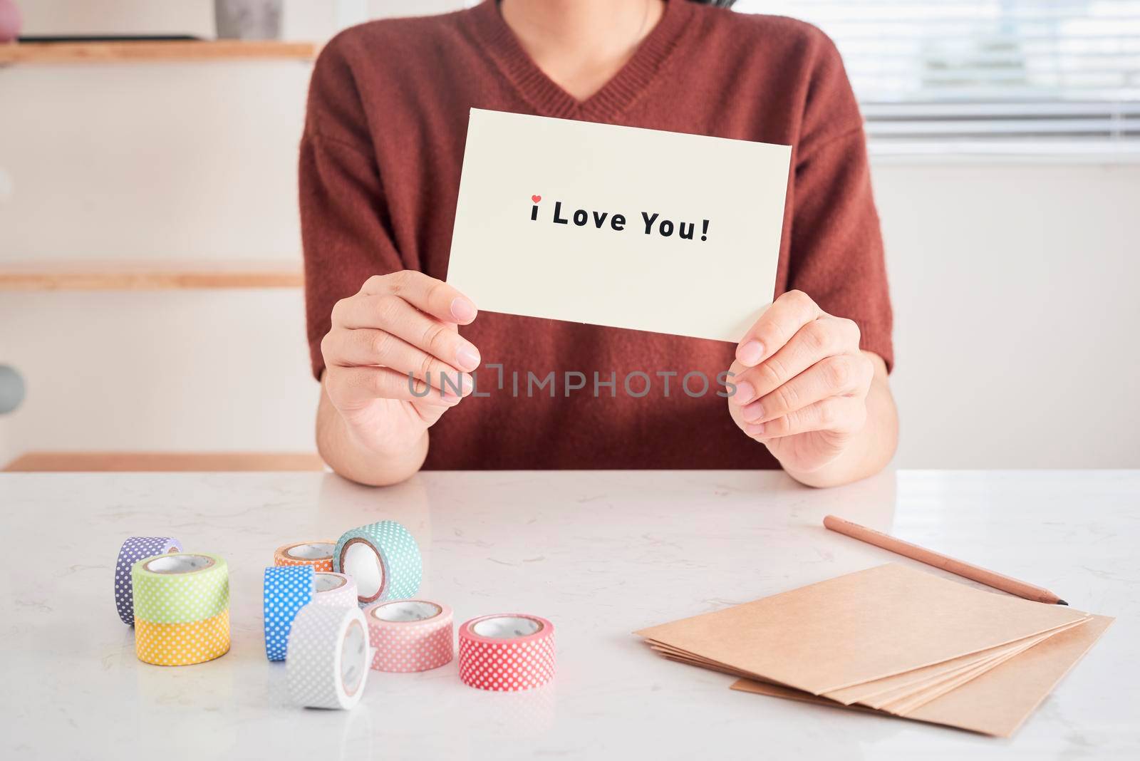 hands holding greeting card with phrase letters "i love you" prepared for sweetheart