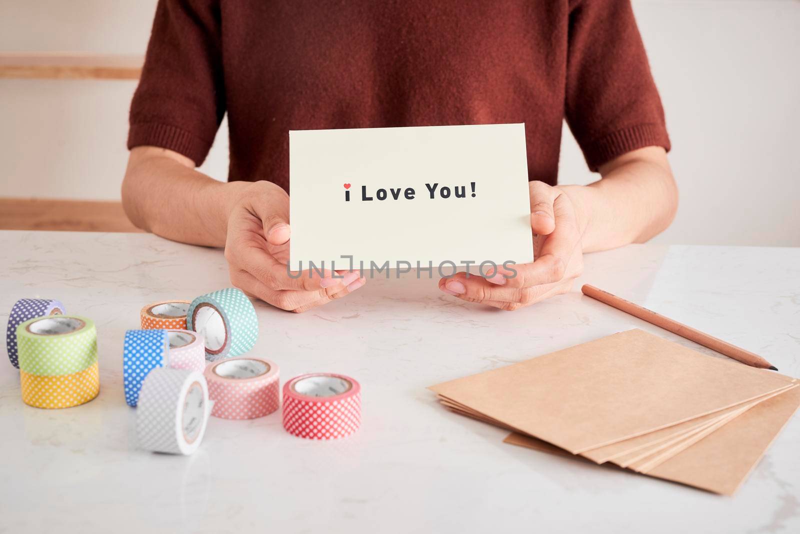 hands holding greeting card with phrase letters "i love you" prepared for sweetheart by makidotvn