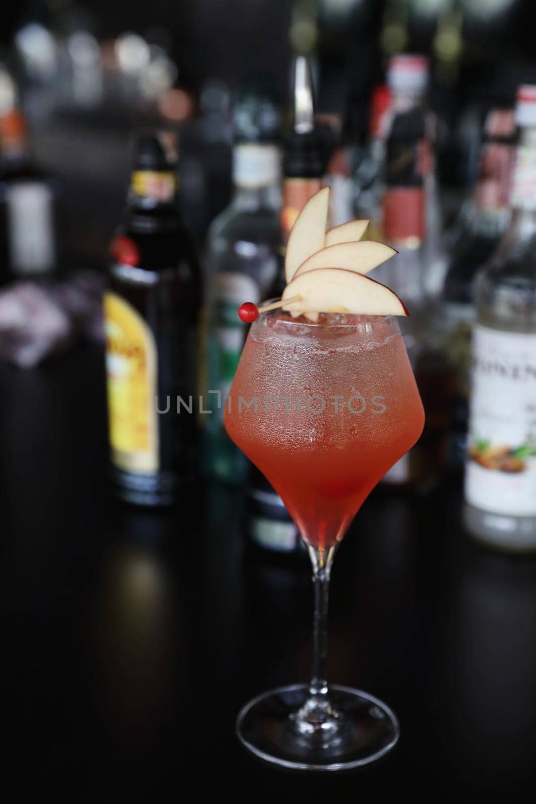 Pink Cocktail glass with ice at a bar counter by piyato