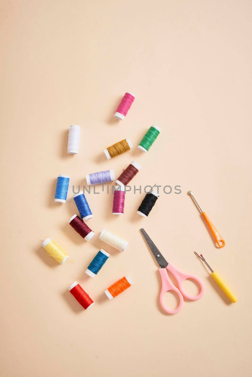 tools for needlework thread scissors and tape measure isolated on biege background  by makidotvn