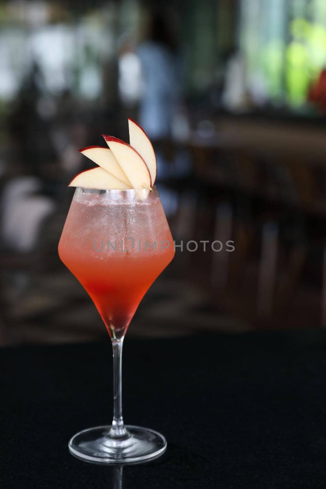 Pink Cocktail glass with ice at a bar counter by piyato