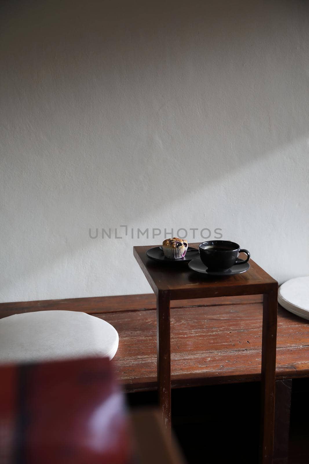 Coffee cup with muffin on wood table in local coffee shop by piyato