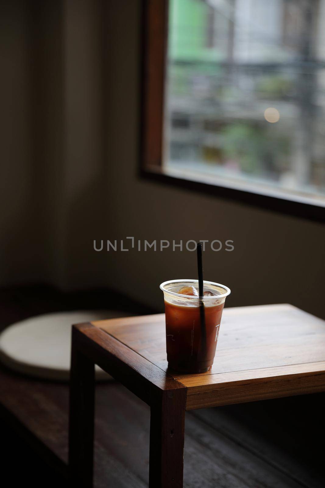 ice coffe on wood table in local coffee shop by piyato