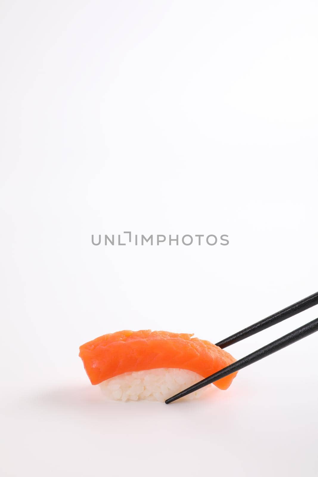 Salmon sushi with chopsticks Japanese food isolated in white background by piyato