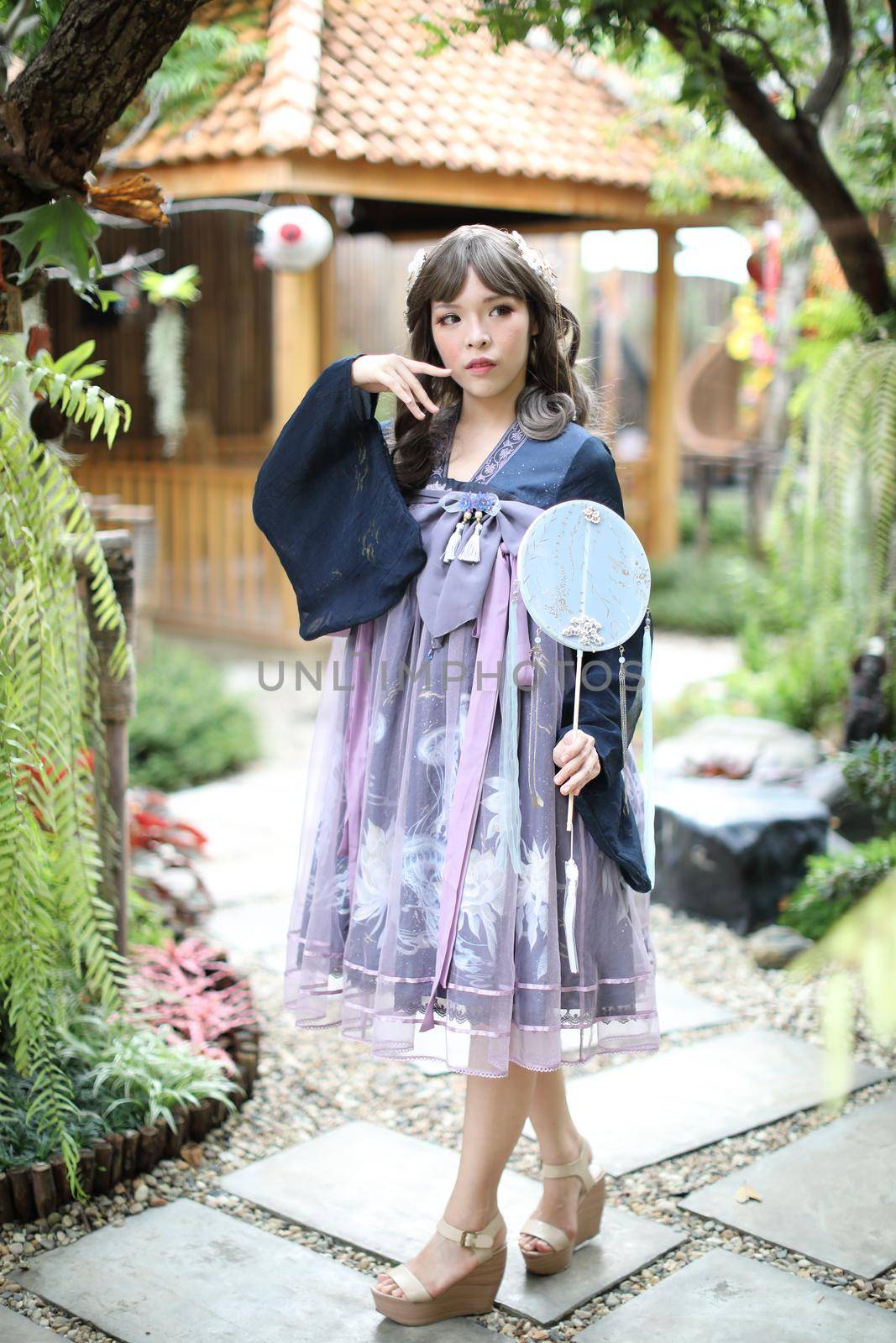 Portrait of asian girl in chinese lolita fashion dress in garden background by piyato