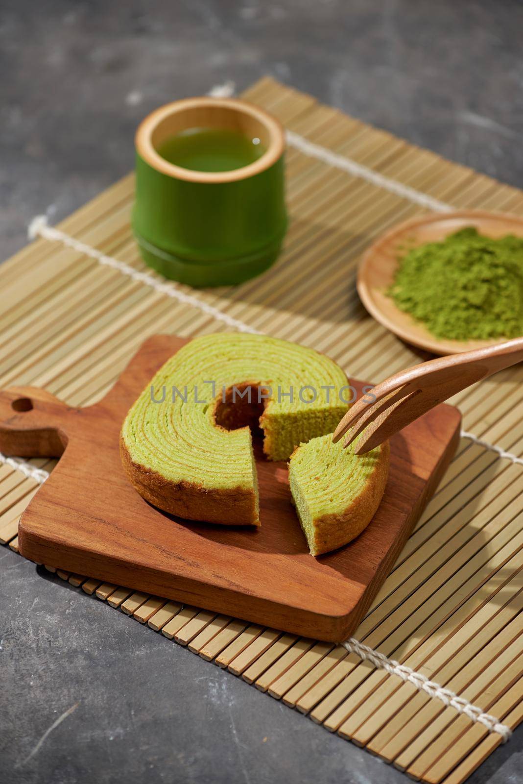 Matcha green tea latte in a cup and tea ceremony utensils with German cake. Copy space