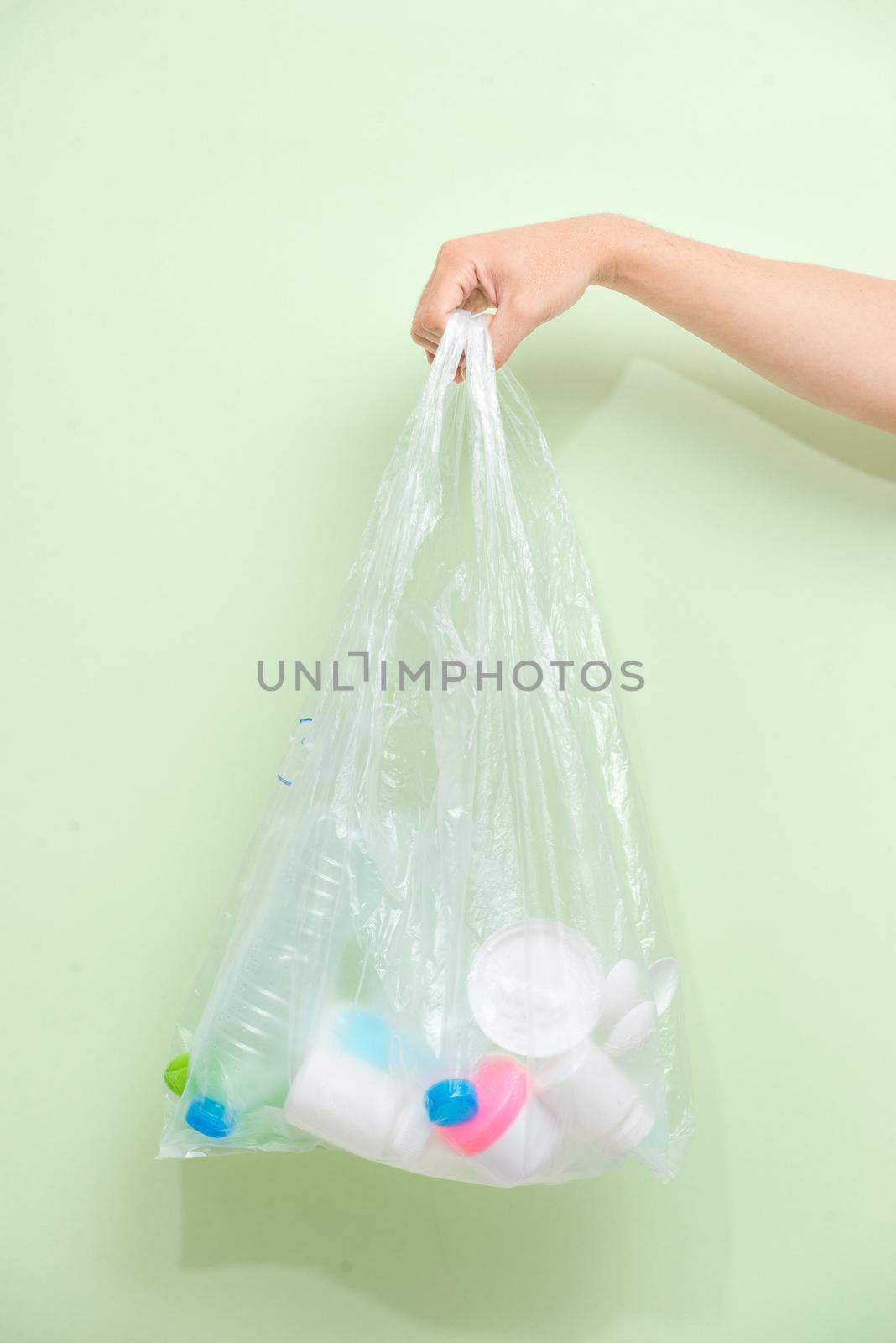Female hand holding a waste bag isolated on white background. by makidotvn