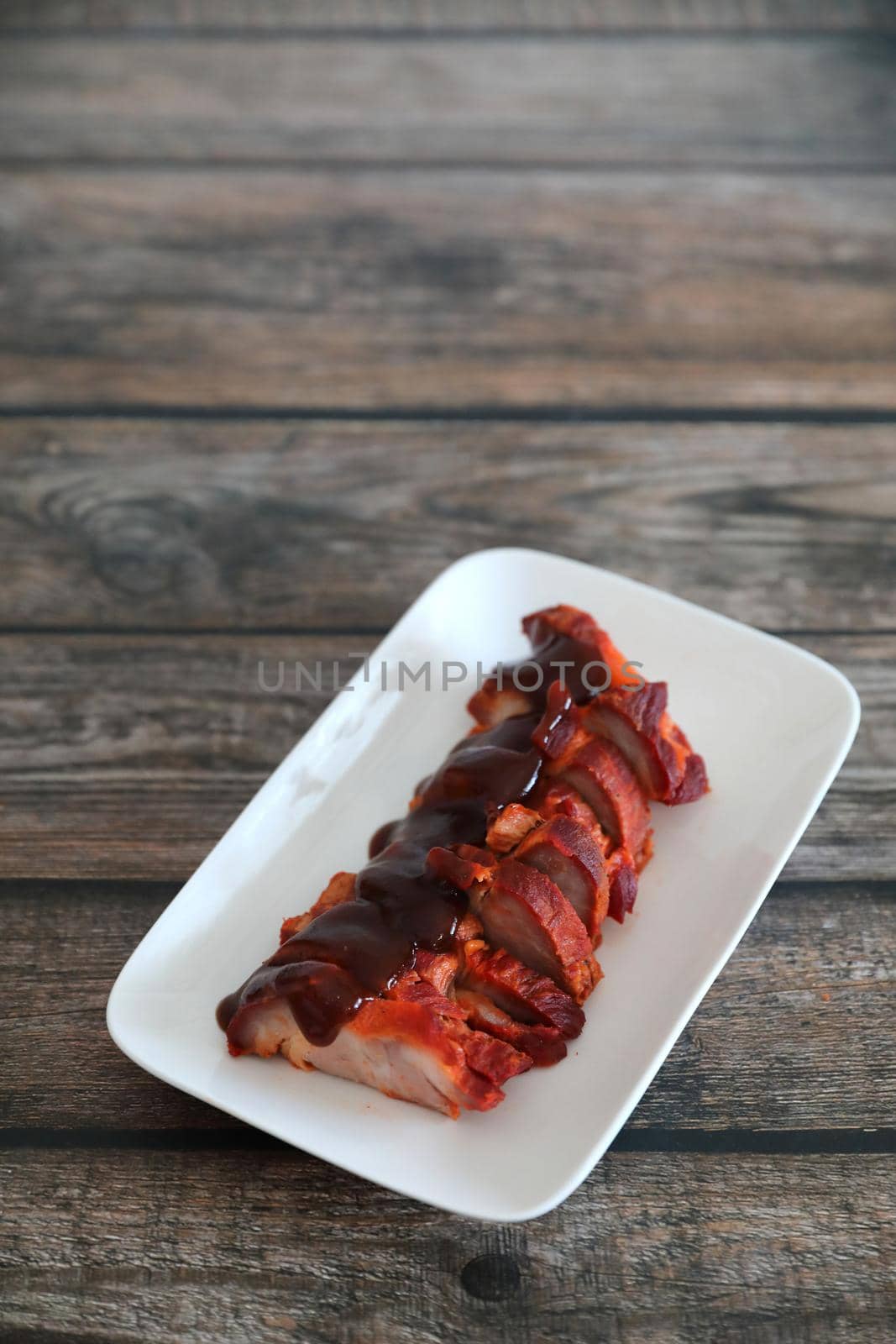 Roasted pork thai local food with red sauce on wood background by piyato