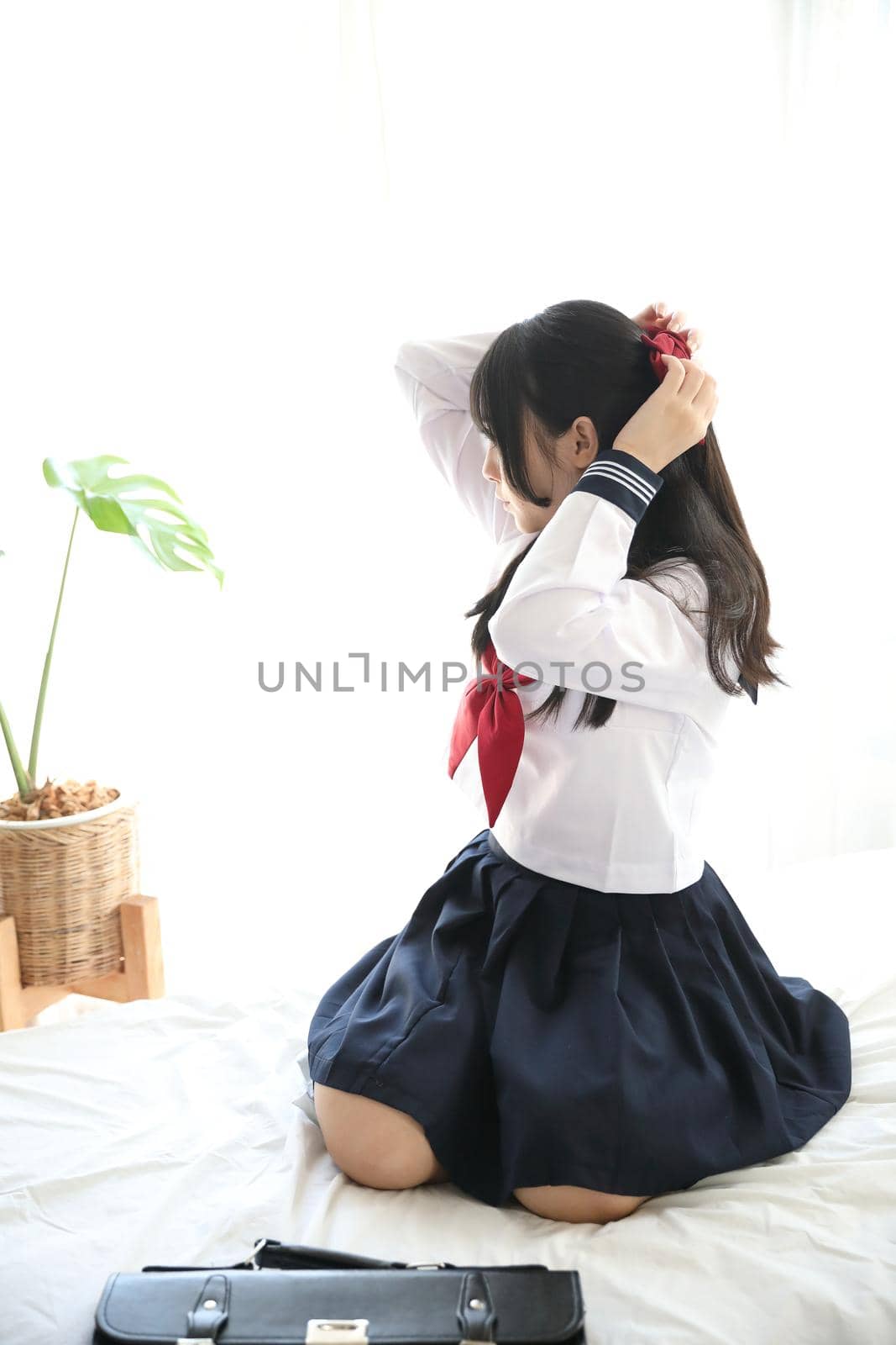 Portrait japanese school girl dressing in white tone bed room