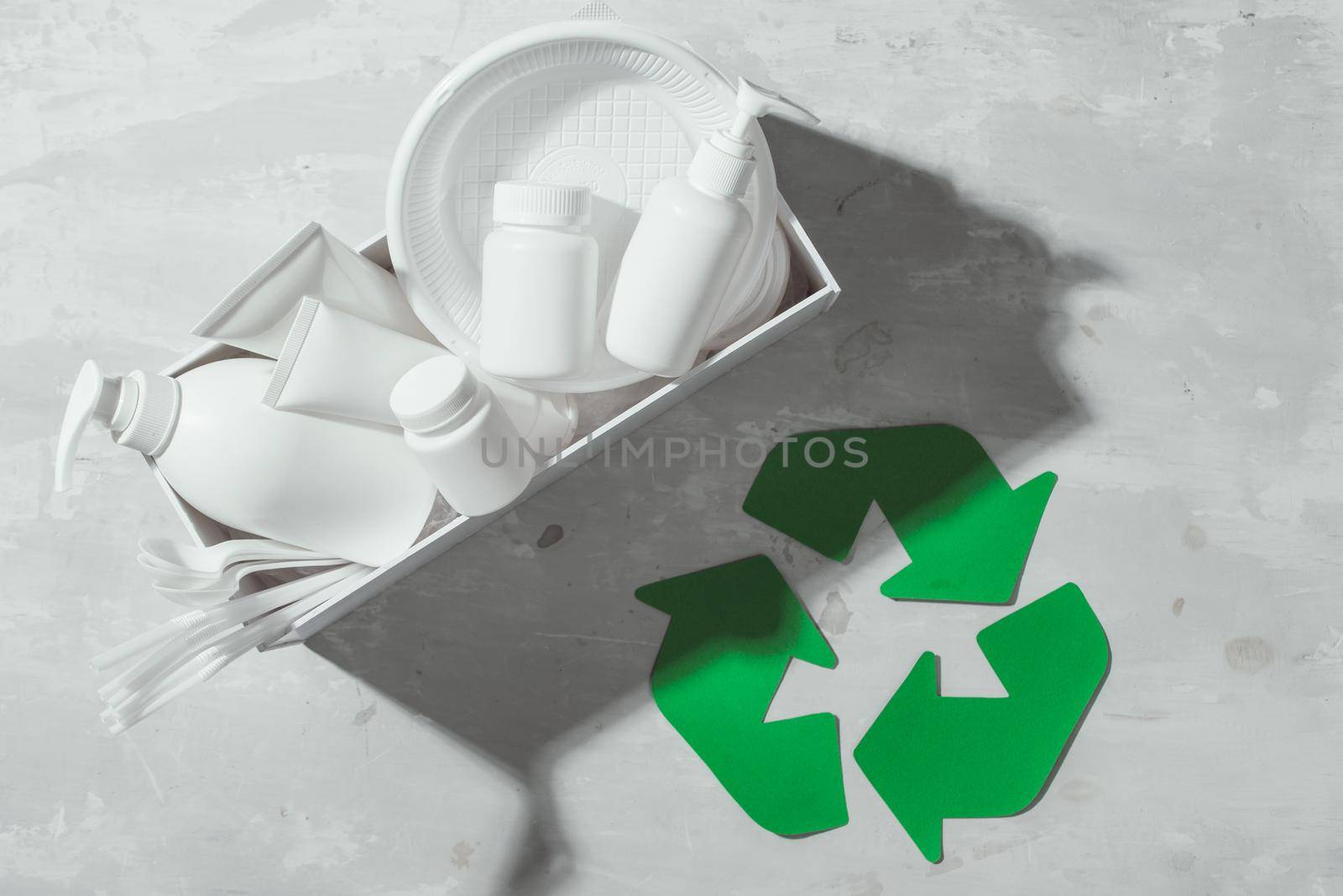 waste recycling eco symbol with garbage disposal on stone table background top view