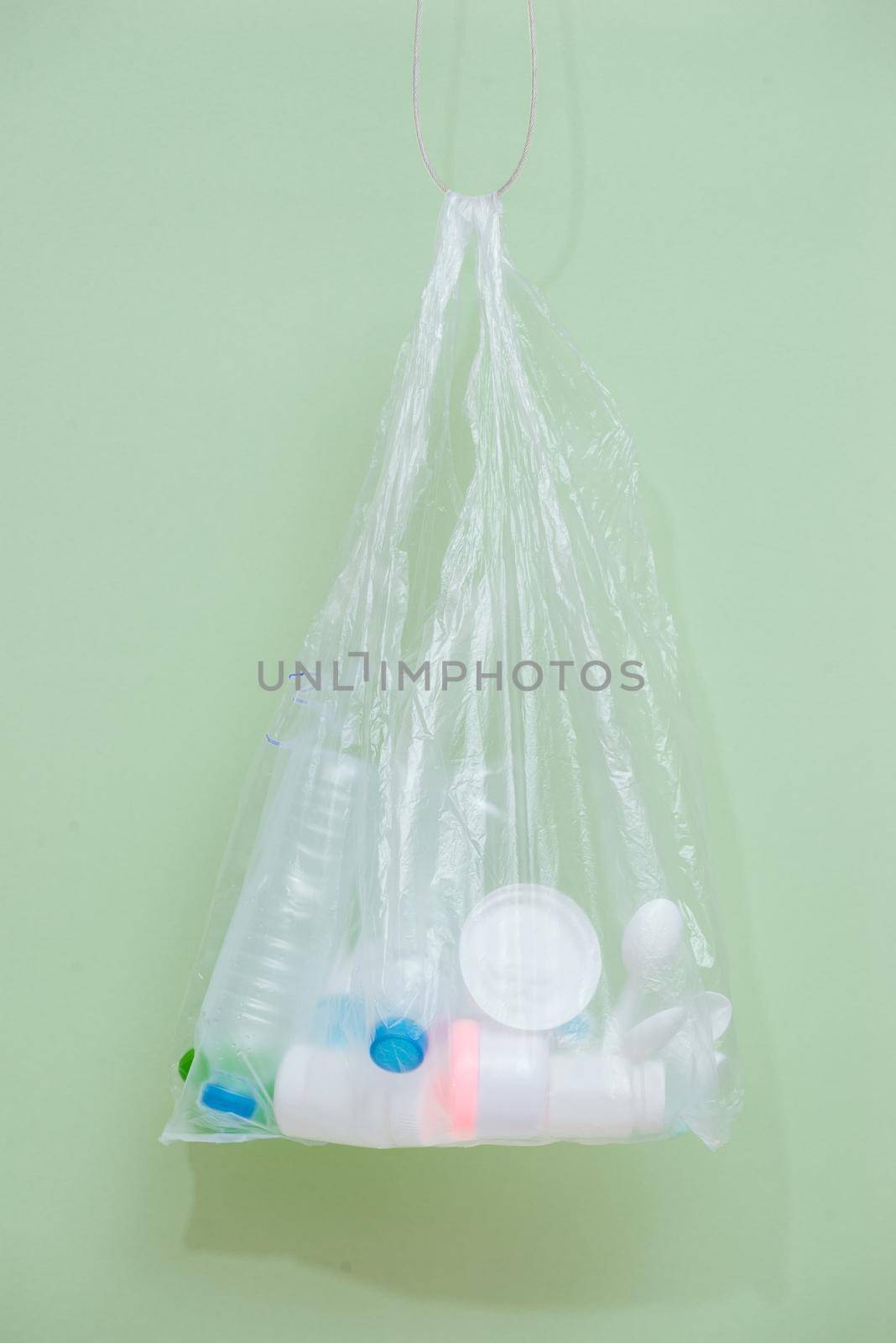 Plastic bag filled with household waste isolated on white background. by makidotvn