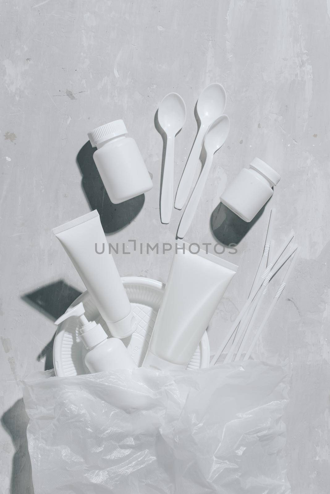 No plastic recycle concept white plastic dishes plates cups spoon on stone background. Copy space. Top view by makidotvn