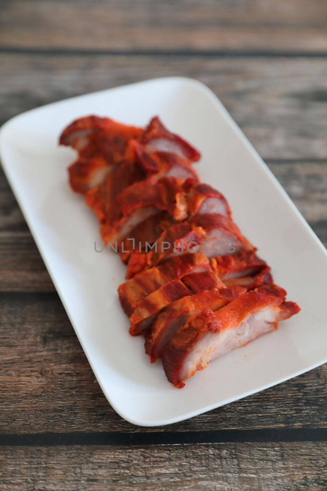 Roasted pork thai local food with red sauce on wood background by piyato