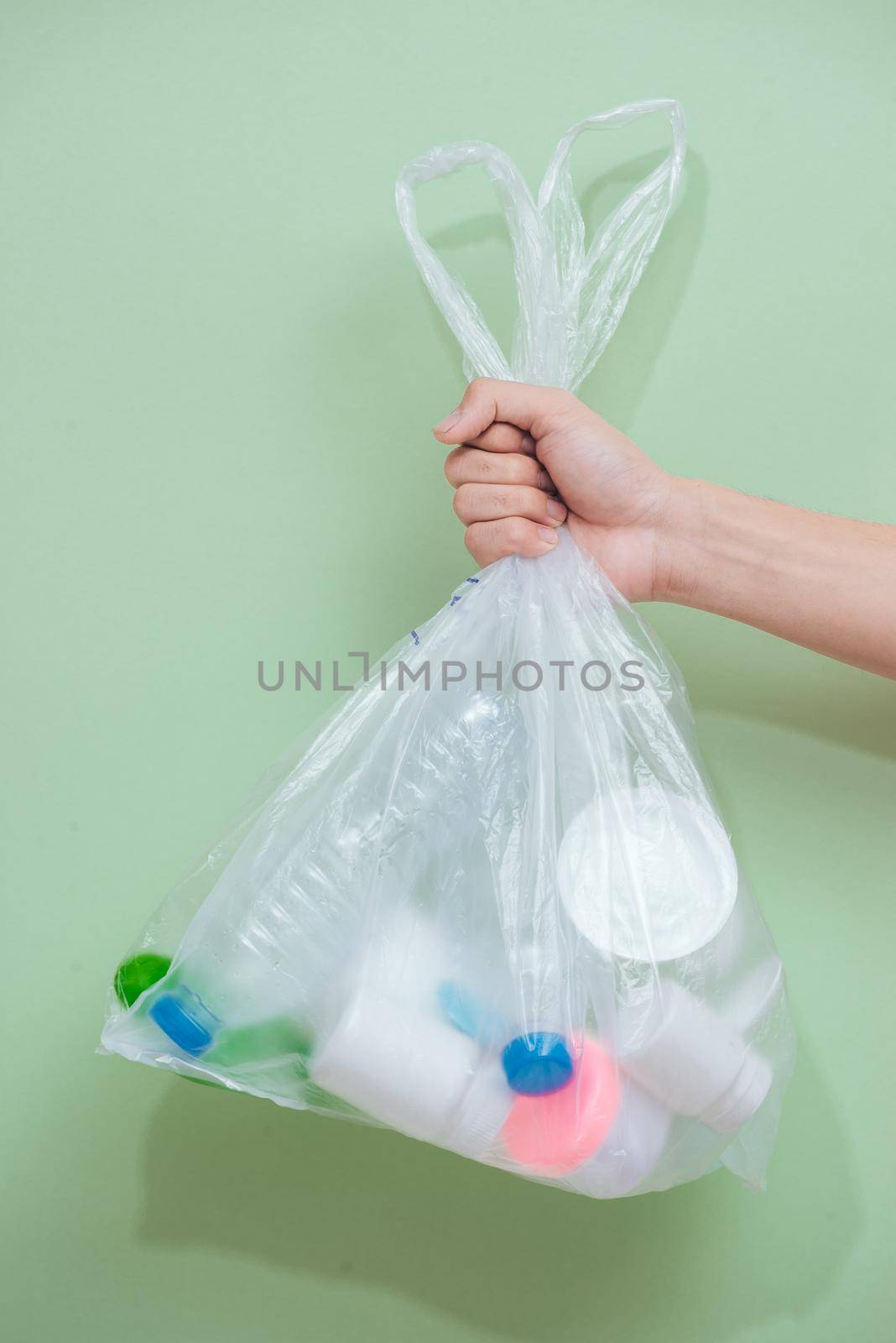 Female hand holding a waste bag isolated on white background.