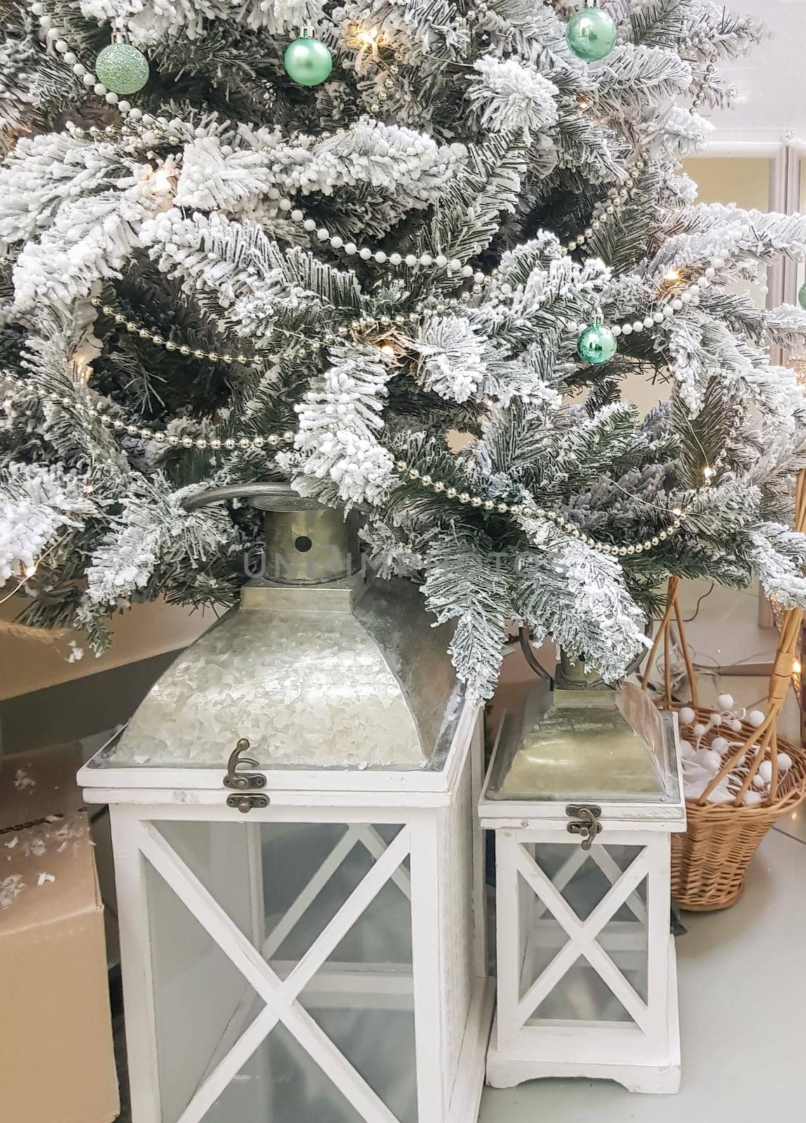 Beautiful composition with vintage Christmas lantern under the Christmas tree with silver branches, vertical.