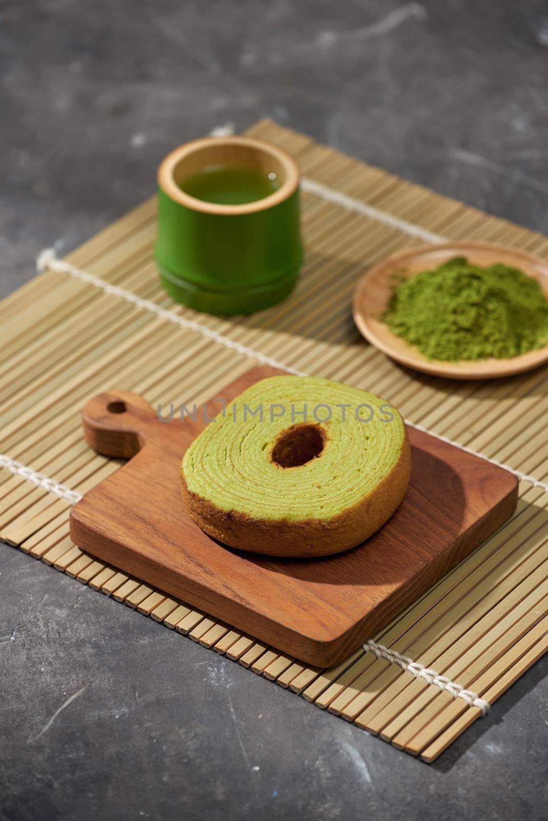 Matcha green tea latte in a cup and tea ceremony utensils with German cake. Copy space by makidotvn