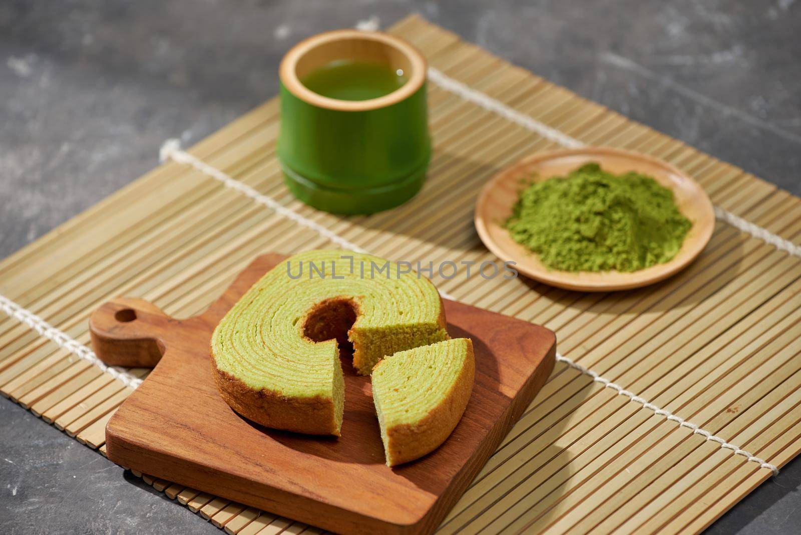 Matcha green tea latte in a cup and tea ceremony utensils with German cake. Copy space