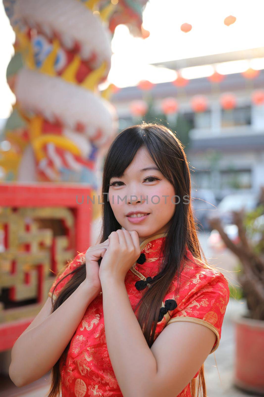 beauty woman wear red cheongsam looking and smile in chinese new year by piyato