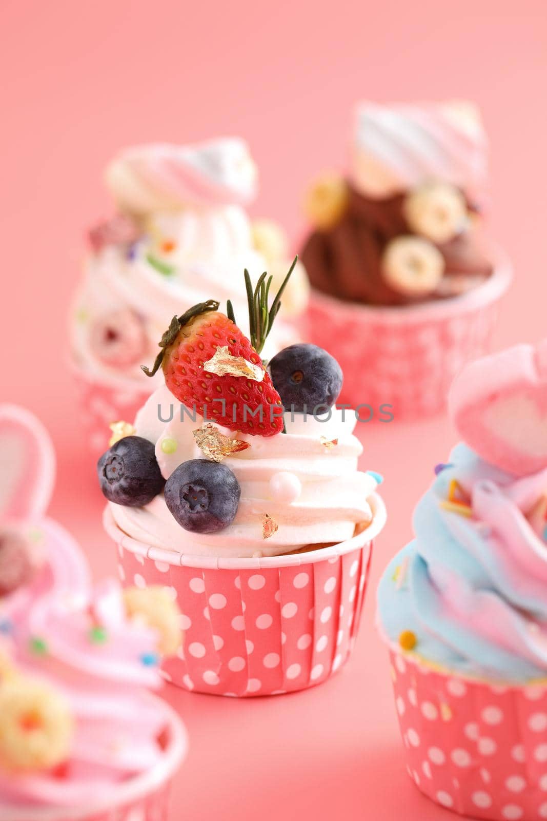 Colorful cupcakes isolated in pink background